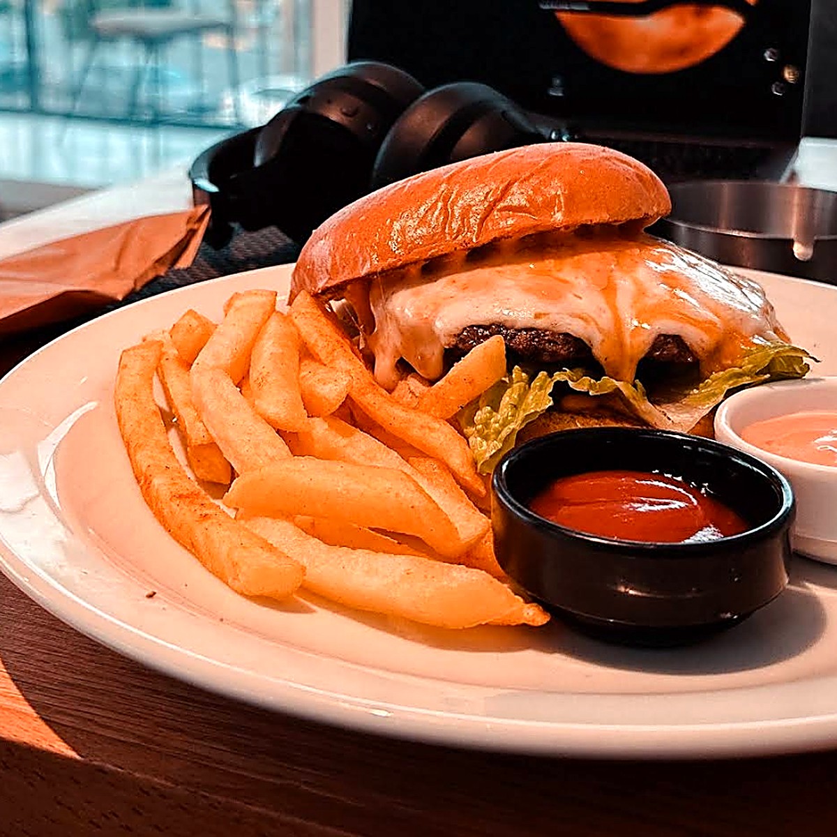 Cheeseburger with melted cheese and fries on a white plate