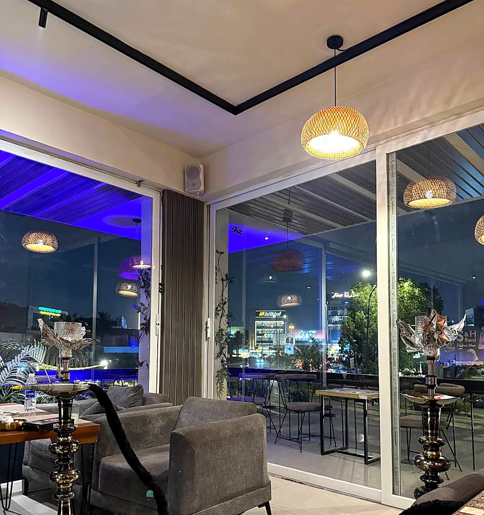 An upper seating area at KAN looking out over the city lights at night